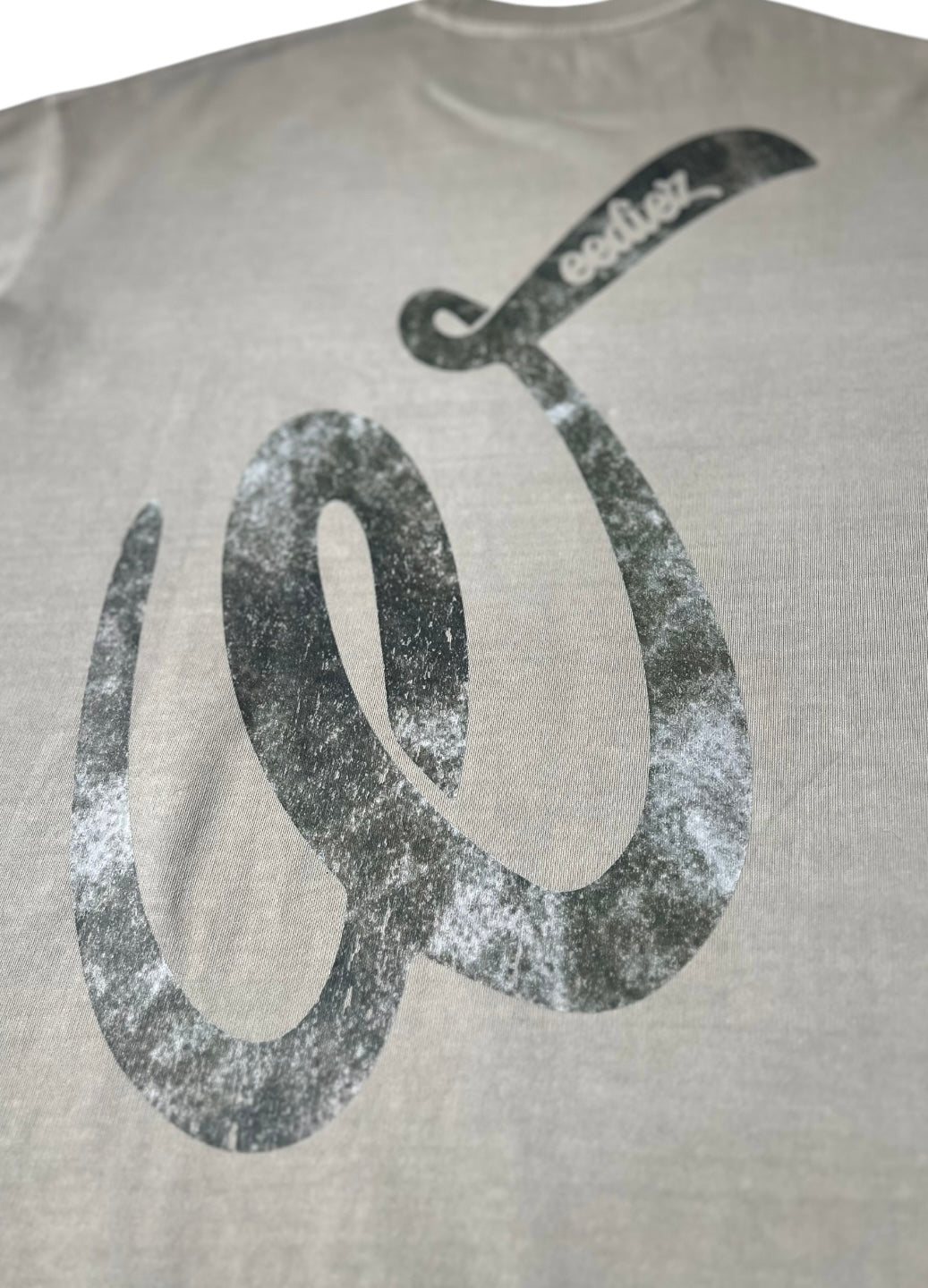 Back side view of Grey signature style T-shirt with Weediez "W" silver colored logo 