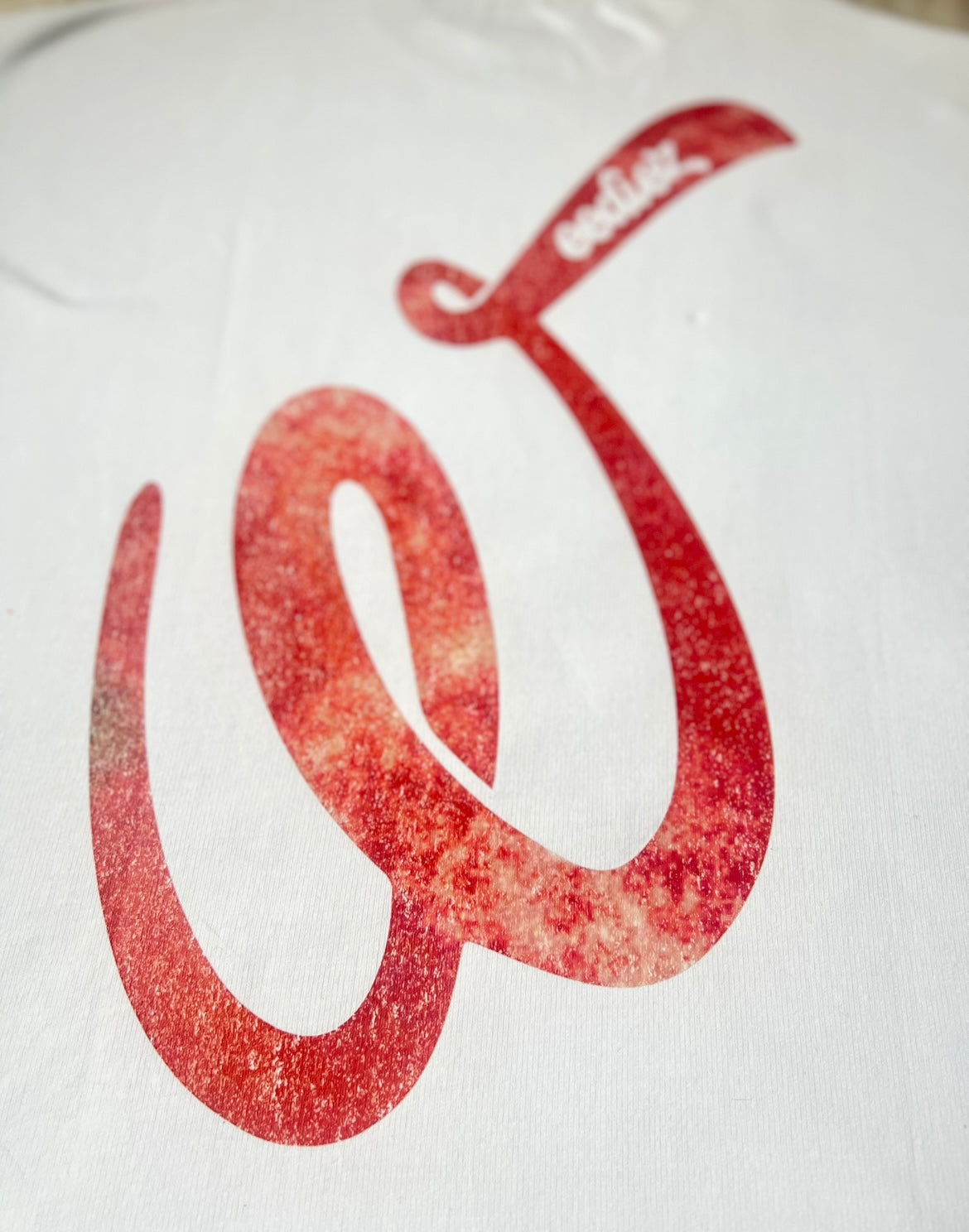 Back side close up view of the white signature style T-shirt with Weediez "W" red colored logo 